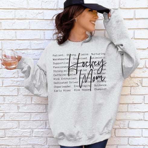 Hockey Mom sweatshirt with handwritten script typography and descriptive text design on a cozy crewneck, perfect for rink moms and hockey season