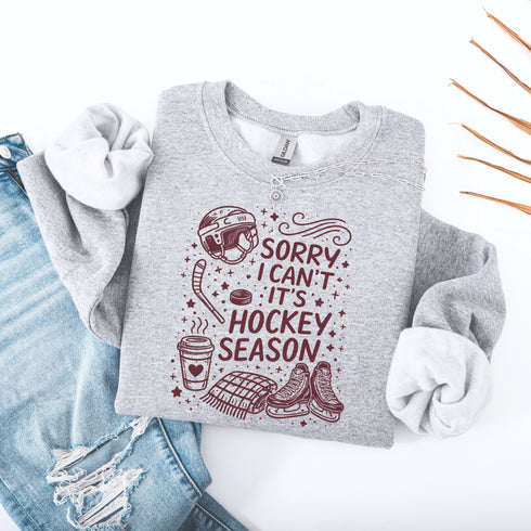 Funny hockey season sweatshirt with “Sorry I Can’t It’s Hockey Season” design featuring skates, stick, puck, and coffee cup – cozy rink apparel for hockey moms and fans