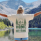 Home Is Out Here Comfort Colors 1717 graphic t-shirt featuring mountain, pine trees, and wilderness artwork with a small left chest logo and large back print.