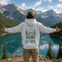 Vintage-inspired outdoor hoodie featuring a coordinating left chest graphic and large back graphic, displayed in a lifestyle mockup inspired by hiking, camping, mountains, lakes, and outdoor adventures.