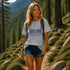 Woman hiking in a forest wearing a t-shirt with a nature-themed design.