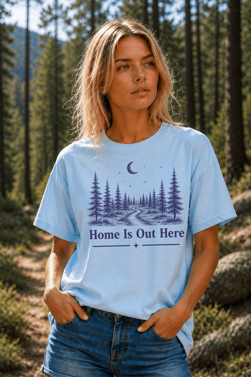 Woman wearing a light blue t-shirt with a nature-themed design in a forest setting
