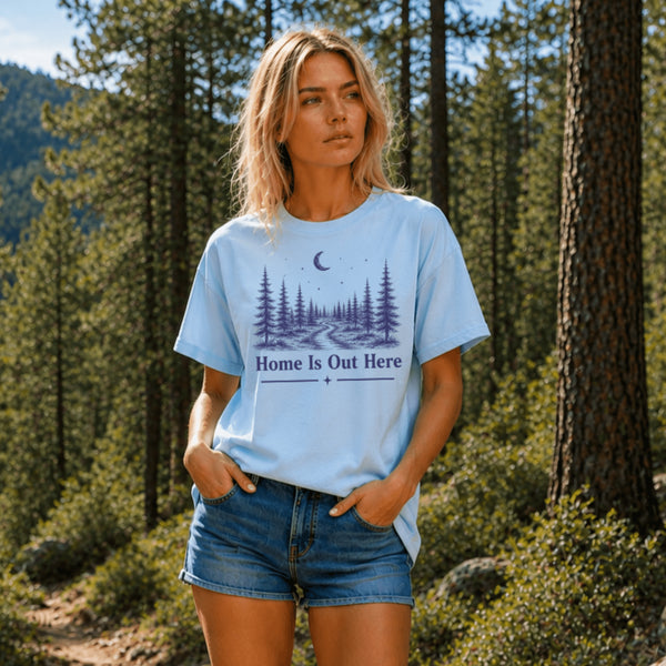 Woman wearing a light blue t-shirt with a nature-themed design in a forest setting