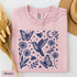 Vintage-inspired hummingbird and butterfly wildflower graphic printed on a Blossom pink Comfort Colors t-shirt.