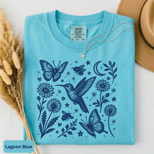 Vintage-inspired hummingbird and butterfly wildflower graphic printed on a Lagoon Blue Comfort Colors t-shirt.