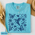 Vintage-inspired hummingbird and butterfly wildflower graphic printed on a Lagoon Blue Comfort Colors t-shirt.