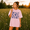 Vintage-inspired hummingbird and butterfly wildflower graphic printed on a Blossom pink Comfort Colors t-shirt.