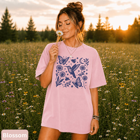 Vintage-inspired hummingbird and butterfly wildflower graphic printed on a Blossom pink Comfort Colors t-shirt.