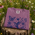 Vintage-inspired hummingbird and butterfly wildflower graphic printed on a Berry colored Comfort Colors t-shirt.