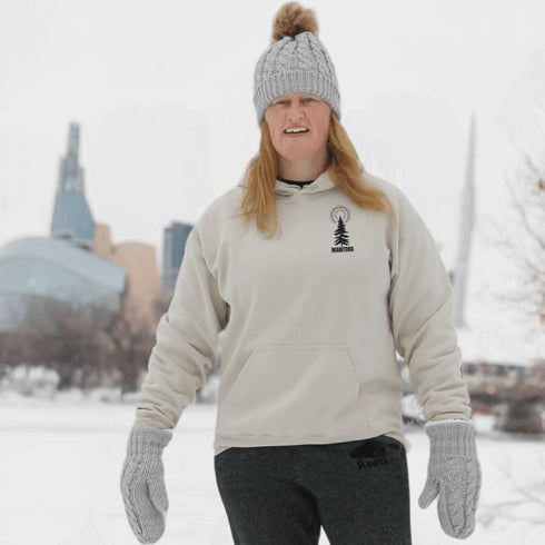 This hoodie features a unique design that showcases the beauty of Manitoba's nature icons, including prairie wheat, geese, bison, trees, and a big sun.