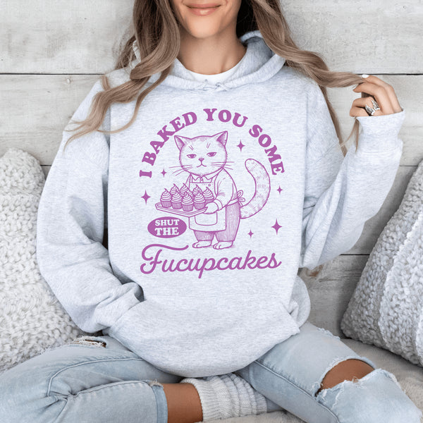 Featuring a sarcastic-looking cat holding a tray of cupcakes, this design pairs sugary sweetness with a healthy dose of sass.