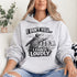 Woman wearing a grey hoodie with “I Don’t Yell I Coach Loudly” soccer coach design featuring coach pointing on sideline with players in background