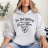 Woman wearing a hoodie that says “I’m Not Yelling This Is My Soccer Mom Voice” with a soccer ball heart design, standing on a soccer field