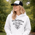 Woman wearing a hoodie that says “I’m Not Yelling This Is My Soccer Mom Voice” with a soccer ball heart design, standing on a soccer field
