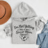 Woman wearing a hoodie that says “I’m Not Yelling This Is My Soccer Mom Voice” with a soccer ball heart design, standing on a soccer field