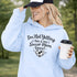 Woman wearing a hoodie that says “I’m Not Yelling This Is My Soccer Mom Voice” with a soccer ball heart design, standing on a soccer field