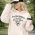 Woman wearing a hoodie that says “I’m Not Yelling This Is My Soccer Mom Voice” with a soccer ball heart design, standing on a soccer field