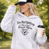 Woman wearing a hoodie that says “I’m Not Yelling This Is My Soccer Mom Voice” with a soccer ball heart design, standing on a soccer field