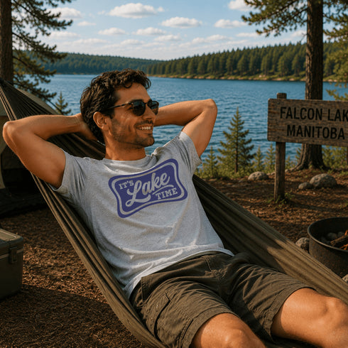 Man relaxing in a hammock by a lake with a 'Falcon Lake Manitoba' sign in the background.