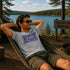 Man relaxing in a hammock by a lake with a 'Falcon Lake Manitoba' sign in the background.