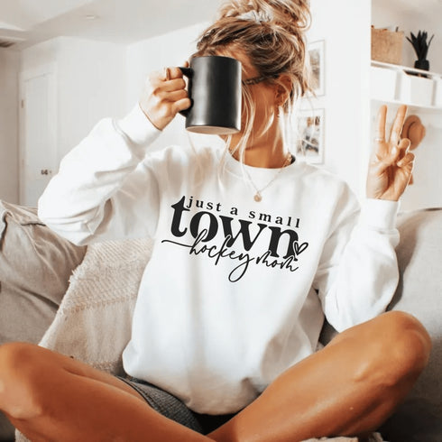Small Town Hockey Mom sweatshirt with black typography design on a cozy white crewneck, perfect for rink moms and hockey season apparel