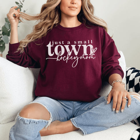 Small Town Hockey Mom sweatshirt with black typography design on a cozy white crewneck, perfect for rink moms and hockey season apparel
