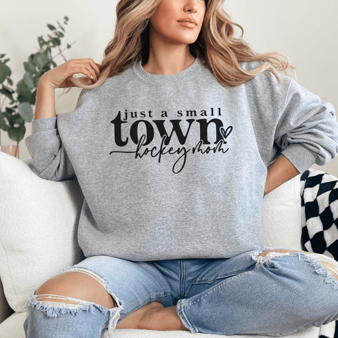 Small Town Hockey Mom sweatshirt with black typography design on a cozy white crewneck, perfect for rink moms and hockey season apparel