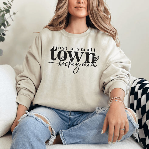 Small Town Hockey Mom sweatshirt with black typography design on a cozy white crewneck, perfect for rink moms and hockey season apparel