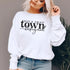 Small Town Hockey Mom sweatshirt with black typography design on a cozy white crewneck, perfect for rink moms and hockey season apparel