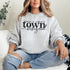 Small Town Hockey Mom sweatshirt with black typography design on a cozy white crewneck, perfect for rink moms and hockey season apparel