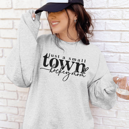 Small Town Hockey Mom sweatshirt with black typography design on a cozy white crewneck, perfect for rink moms and hockey season apparel