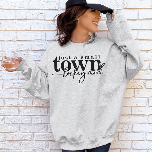 Small Town Hockey Mom sweatshirt with black typography design on a cozy white crewneck, perfect for rink moms and hockey season apparel