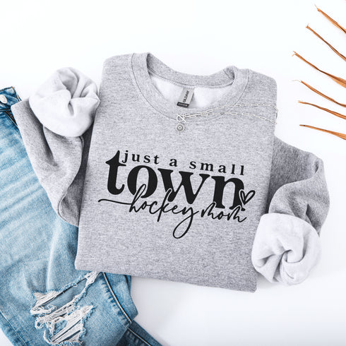 Small Town Hockey Mom sweatshirt with black typography design on a cozy white crewneck, perfect for rink moms and hockey season apparel