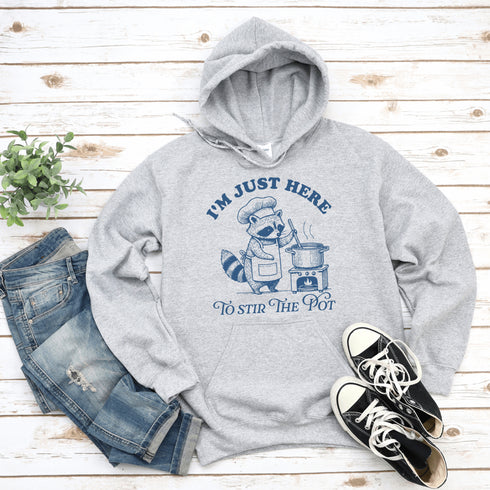 Meet your new favorite hoodie—starring a sarcastic raccoon who’s as skilled at cooking up drama as stirring actual soup.