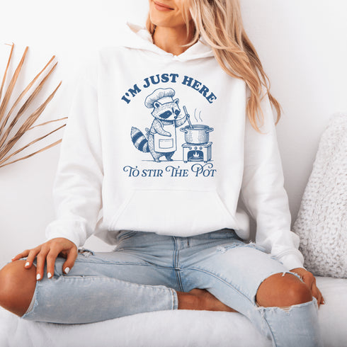 Meet your new favorite hoodie—starring a sarcastic raccoon who’s as skilled at cooking up drama as stirring actual soup.
