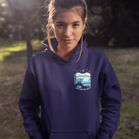 This hoodie features a silhouetted polar bear wandering across layered frozen prairie hills, this design captures the quiet majesty of nature.