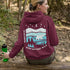 This hoodie features a silhouetted polar bear wandering across layered frozen prairie hills, this design captures the quiet majesty of nature.