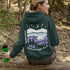 Featuring a sleek polar bear silhouette wandering through layered frozen prairie hills, this hoodie design evokes the serenity of untouched nature.