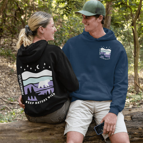 Featuring a sleek polar bear silhouette wandering through layered frozen prairie hills, this hoodie design evokes the serenity of untouched nature.