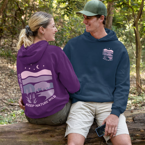 The hoodie showcases a bison standing above wheat with an open prairie sky, blending modern style with the wild spirit of the Canadian countryside.