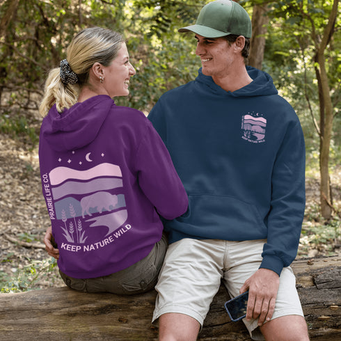The hoodie showcases a bison standing above wheat with an open prairie sky, blending modern style with the wild spirit of the Canadian countryside.