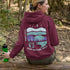 This hoodie features a color-blocked design in pastel blue and purple hues. The graphic showcases a powerful bison standing above wheat with an open prairie sky