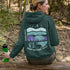 This hoodie features a color-blocked design in pastel blue and purple hues. The graphic showcases a powerful bison standing above wheat with an open prairie sky