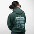 This hoodie features a color-blocked design in pastel blue and purple hues. The graphic showcases a powerful bison standing above wheat with an open prairie sky