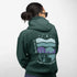 This hoodie features a color-blocked design in pastel blue and purple hues. The graphic showcases a powerful bison standing above wheat with an open prairie sky