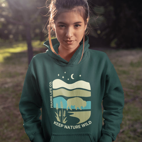 Featuring a bold yet minimalist bison silhouette set against layered prairie landscapes, moonlit skies, and winding waterways, this design captures prairie life.