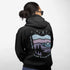 This hoodie features a nature graphic showcasing prairie hills, pine trees, a cozy tent, and a glowing campfire under a crescent moon and star-filled sky.