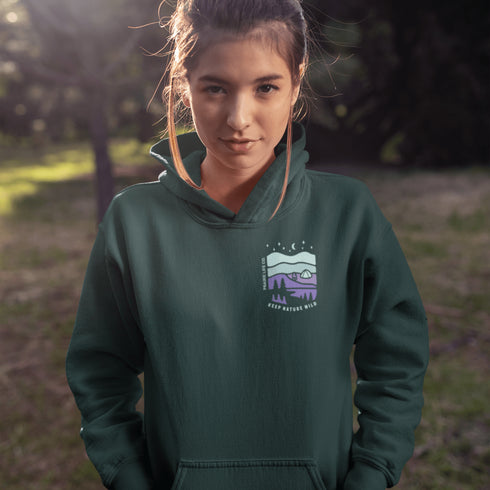This hoodie features a retro-style landscape graphic with prairie hills, pine trees, a campfire, a tent, and a night sky filled with stars and a crescent moon.