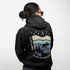 This hoodie features a moose silhouette roaming across prairie hills, pine trees with stars scattered above and a crescent moon glowing softly.