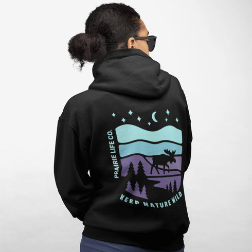 Featuring a bold moose silhouette set against a serene forest landscape, this design celebrates adventure, conservation, and life beyond the pavement.